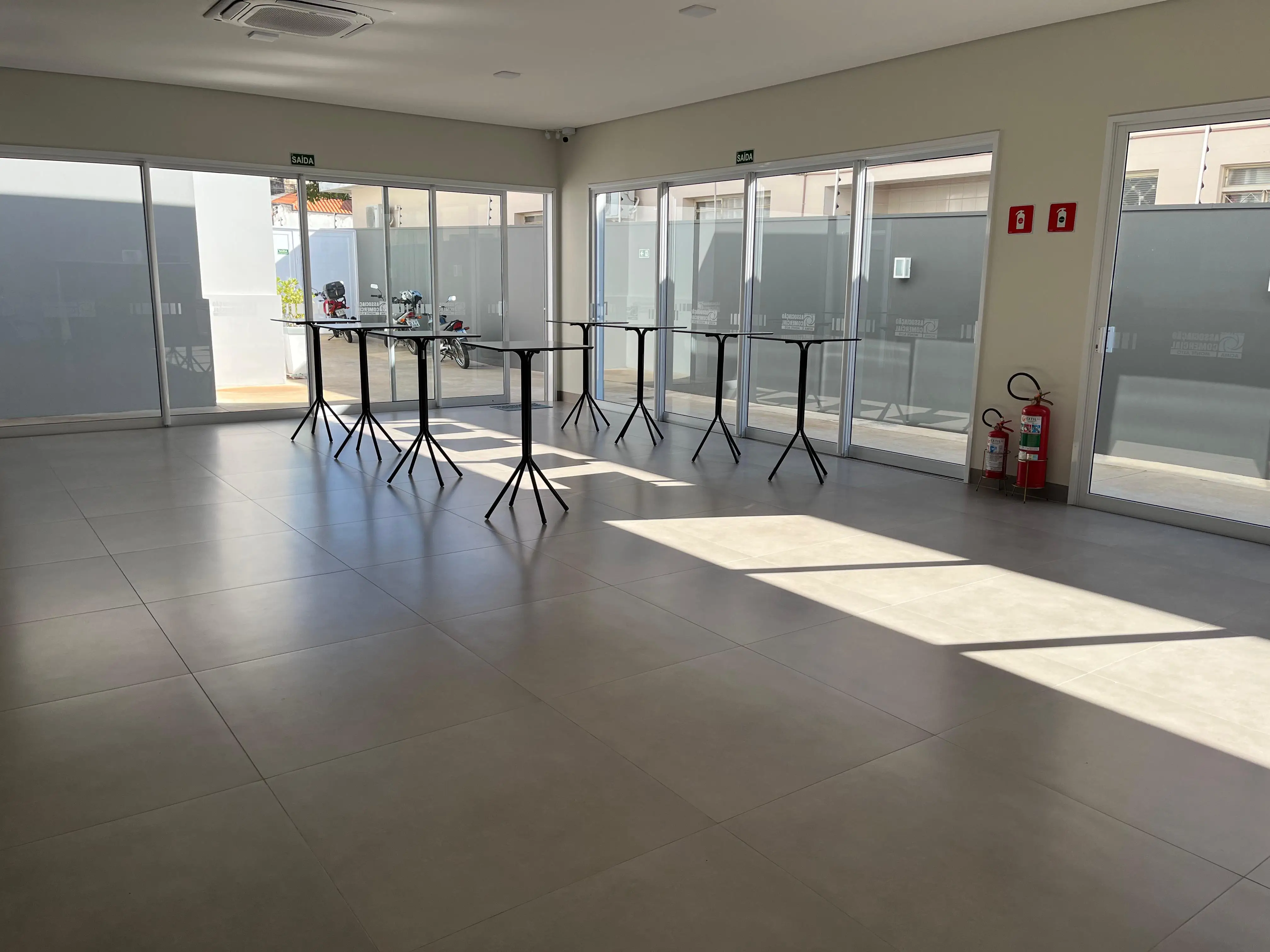 Foto da sala gourmet, nela mostra o tamanho do salão com 10 mesas.